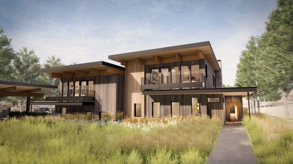 Modern two-story house with wooden siding, large windows, balconies, and a flat roof, surrounded by tall grass and trees under a partly cloudy sky, offers stunning vineyard views in the heart of North Central Washington’s Rocky Pond Estate.
